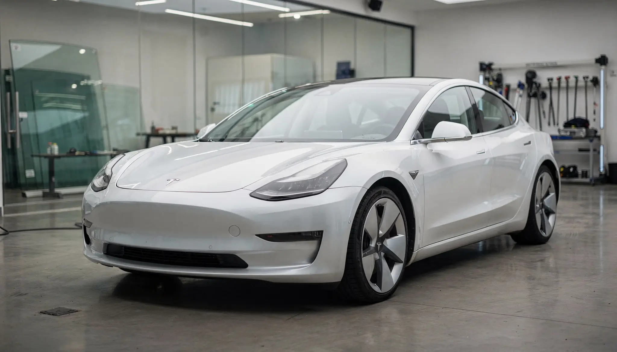 Illustrative white four-door sedan in a studio